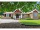 Charming single-story home with a unique facade, decorative trim, and lush greenery at 821 Woodburn Rd, Raleigh, NC 27605