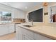 Well-lit kitchen with white cabinets, stone countertops, stainless steel appliances, and decorative backsplash at 821 Woodburn Rd, Raleigh, NC 27605