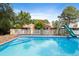Backyard pool with a slide and diving board that is surrounded by a white fence and greenery at 821 Woodburn Rd, Raleigh, NC 27605