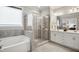 Bathroom featuring a separate tub and shower, dual sinks, and neutral tile at 8909 Tara Hill Ln, Wake Forest, NC 27587