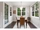 Sunlit breakfast nook with hardwood floors, white trim, and a view of the outdoor greenery at 8909 Tara Hill Ln, Wake Forest, NC 27587