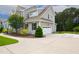 Long driveway leads to a two-car garage, with a view of the home's architecture and landscaping at 8909 Tara Hill Ln, Wake Forest, NC 27587