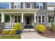Close-up of a welcoming front porch with stone columns, a dark door, and decorative plants at 8909 Tara Hill Ln, Wake Forest, NC 27587