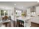 Bright, open kitchen features an island with seating, white cabinetry, and stainless steel appliances at 8909 Tara Hill Ln, Wake Forest, NC 27587