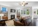 Spacious living room with a fireplace, large leather sofa, and bright windows overlooking the yard at 8909 Tara Hill Ln, Wake Forest, NC 27587