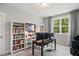 Bright home office with built-in bookshelves, desk, and natural light from a large window at 8909 Tara Hill Ln, Wake Forest, NC 27587