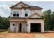 Unfinished two-story home with visible framework, siding wrap, and a two car garage awaiting completion at 95 Goldenrod Loop, Clayton, NC 27520
