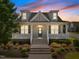 Charming home featuring dormer windows, a welcoming front porch with white columns and manicured landscaping at 1000 Groveview Wynd, Wendell, NC 27591