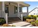 Close up of the charming front porch featuring a brick staircase and detailed railing at 1000 Groveview Wynd, Wendell, NC 27591