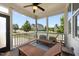 A covered patio with wood flooring, ceiling fan and wooden furniture with a neighborhood view at 1000 Groveview Wynd, Wendell, NC 27591