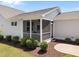 Side view of home featuring a screened porch with white railing and manicured landscaping at 1000 Groveview Wynd, Wendell, NC 27591