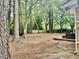 Lush backyard with mature trees, an outdoor seating area, a wooden deck, and a privacy fence at 1006 Aversboro Rd, Garner, NC 27529