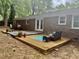 Brick house exterior with wood deck, outdoor seating, lovely potted plants, and French doors at 1006 Aversboro Rd, Garner, NC 27529