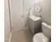 Compact bathroom with a gray vanity, a round mirror, and a toilet, all illuminated by modern lighting at 1006 Aversboro Rd, Garner, NC 27529