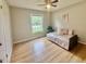 Bright bedroom with hardwood floors, a ceiling fan, a window, and a cozy daybed with decorative pillows at 1006 Aversboro Rd, Garner, NC 27529