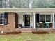 Inviting front porch with seating area, flower beds and brick accents at 1006 Aversboro Rd, Garner, NC 27529