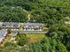 Aerial view of townhomes with a pond nearby and surrounded by dense forest at 1017 Frank Page Dr, Cary, NC 27511