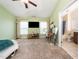 Carpeted bedroom with mounted TV, desk, and ensuite bathroom with tub and shower at 1017 Frank Page Dr, Cary, NC 27511