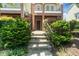 Brick townhouse with a charming front entrance, featuring a garden and a few steps leading up to a brown front door at 1017 Frank Page Dr, Cary, NC 27511