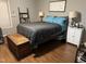 Cozy bedroom featuring wood floors, blue linens and a decorative wooden chest at 104 Holly Ranch Ct, Willow Springs, NC 27592