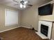 Comfortable living room with a fireplace, hardwood floors, ceiling fan and mounted television at 104 Holly Ranch Ct, Willow Springs, NC 27592