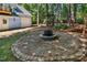 Scenic backyard with a stone fire pit, a swing, and wooded surroundings with a blue home nearby at 104 Shady Ridge Ct, Apex, NC 27502