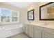 Spacious bathroom with dual sinks, vanity, tub, and a large window at 104 Shady Ridge Ct, Apex, NC 27502