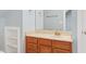 Bathroom vanity with wood cabinets and a decorative mirror, with extra shelving to the side at 104 Shady Ridge Ct, Apex, NC 27502