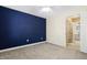 Inviting bedroom with a blue accent wall, neutral carpet, and access to a bathroom, offering a stylish retreat at 104 Shady Ridge Ct, Apex, NC 27502