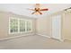 Spacious room with neutral carpet, large windows providing ample natural light, and a ceiling fan at 104 Shady Ridge Ct, Apex, NC 27502