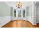 Elegant dining room featuring hardwood floors, wainscoting, chandelier, and abundant natural light at 104 Shady Ridge Ct, Apex, NC 27502