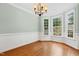 Elegant dining room featuring hardwood floors, wainscoting, chandelier, and abundant natural light at 104 Shady Ridge Ct, Apex, NC 27502
