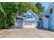 Charming two-story light blue home with a three-car garage and lush green trees at 104 Shady Ridge Ct, Apex, NC 27502