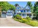 Charming two-story home with light blue siding, white trim, front porch, and an attached two car garage at 104 Shady Ridge Ct, Apex, NC 27502