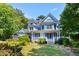 Beautiful light-blue Victorian-style home with a well-manicured lawn and colorful landscaping at 104 Shady Ridge Ct, Apex, NC 27502