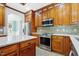 The kitchen has wooden cabinets, stainless steel appliances, a tile backsplash, and a kitchen island at 104 Shady Ridge Ct, Apex, NC 27502