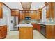 This is a full kitchen view with wood cabinets, a kitchen island, stainless steel appliances, and tile backsplash at 104 Shady Ridge Ct, Apex, NC 27502