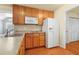Functional kitchen featuring wood cabinets, white appliances, and an efficient layout at 104 Shady Ridge Ct, Apex, NC 27502