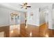 This is a view of the living room with hardwood floors, white walls, and a sunroom area at 104 Shady Ridge Ct, Apex, NC 27502