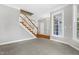 Spacious living room with neutral walls, carpet, white trim and staircase to upper level at 104 Shady Ridge Ct, Apex, NC 27502