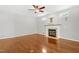 This living room features hardwood floors, a fireplace, white walls, and a ceiling fan at 104 Shady Ridge Ct, Apex, NC 27502