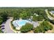 Aerial view of a community swimming pool with blue lounge chairs and umbrellas surrounded by green trees at 104 Shady Ridge Ct, Apex, NC 27502