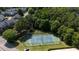 Aerial view of a blue and green tennis court surrounded by trees and residential buildings at 104 Shady Ridge Ct, Apex, NC 27502