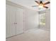 Bright bedroom featuring carpet flooring, a ceiling fan, and a closet, offering a comfortable living space at 104 Trinity Grove Dr, Cary, NC 27513