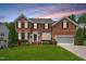 Charming two-story brick home with manicured lawn and beautiful landscaping at 104 Trinity Grove Dr, Cary, NC 27513