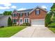 Beautiful two-story brick home with an attached garage, manicured lawn and mature landscaping at 104 Trinity Grove Dr, Cary, NC 27513