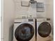 Modern laundry room with front-load washer and dryer, wire shelving, and neutral wall color at 104 Trinity Grove Dr, Cary, NC 27513