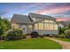 Charming home featuring a sunroom, stone patio, and well-maintained lawn, perfect for outdoor entertaining at 104 Trinity Grove Dr, Cary, NC 27513