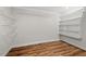 Walk-in closet featuring wood-look floors, installed white wire and built-in shelving at 106 Choptank Ct # B-2, Cary, NC 27513