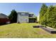 Large backyard with well-maintained lawn, raised garden beds, and a view of the house at 1104 Pebblestone Drive, Durham, NC 27703